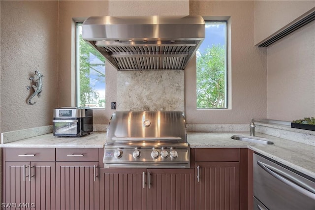 kitchen featuring light stone countertops, extractor fan, and plenty of natural light