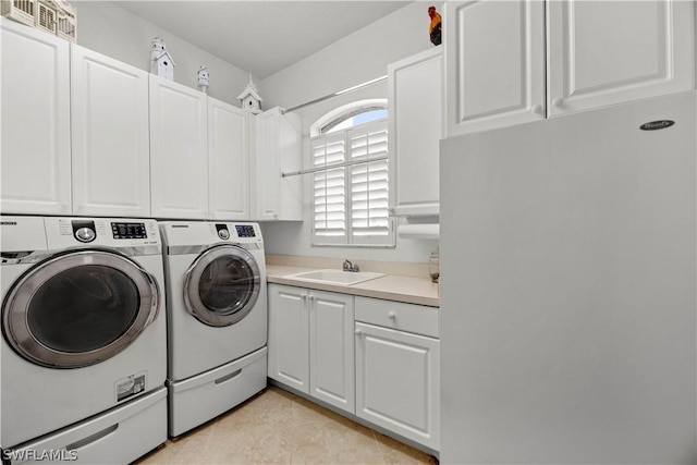 washroom featuring cabinet space, light tile patterned flooring, a sink, and washing machine and clothes dryer