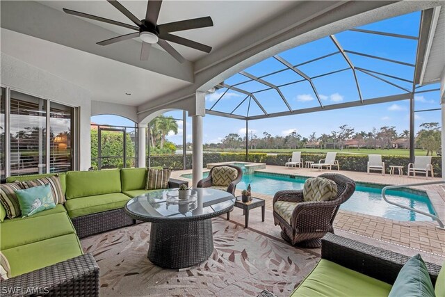 view of patio / terrace featuring ceiling fan, a pool with hot tub, a lanai, and an outdoor hangout area