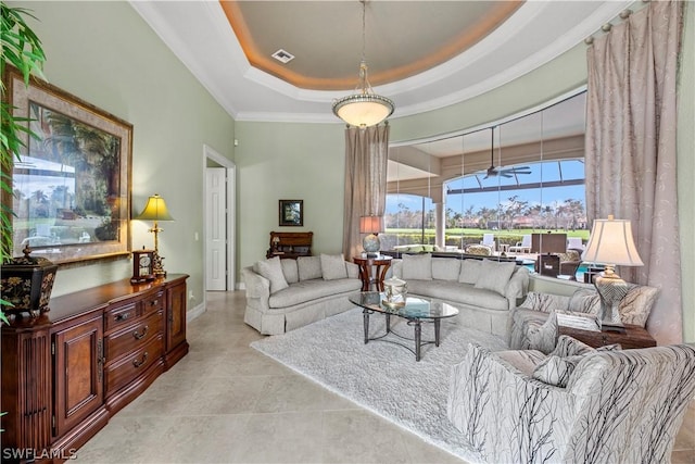 tiled living room with a ceiling fan, a tray ceiling, and visible vents