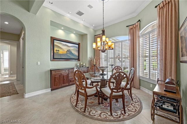 dining area featuring arched walkways, light tile patterned floors, visible vents, baseboards, and crown molding