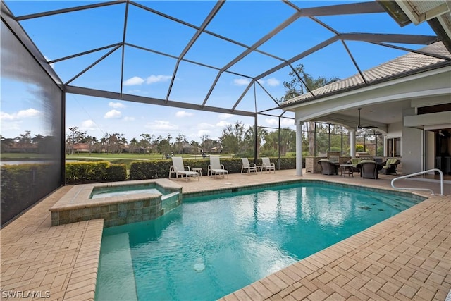 view of pool featuring glass enclosure, a pool with connected hot tub, and a patio area