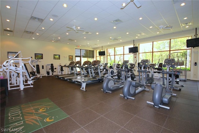 workout area with a drop ceiling, visible vents, and a ceiling fan