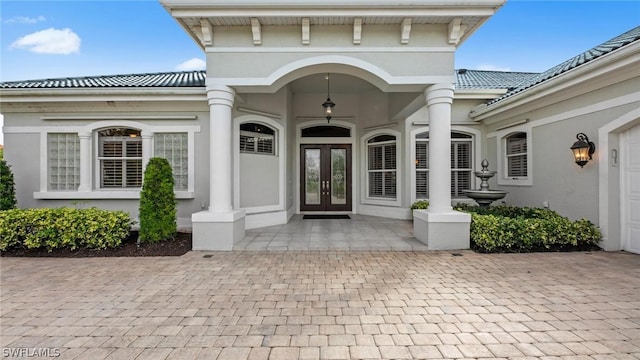 doorway to property featuring stucco siding, a tiled roof, and french doors