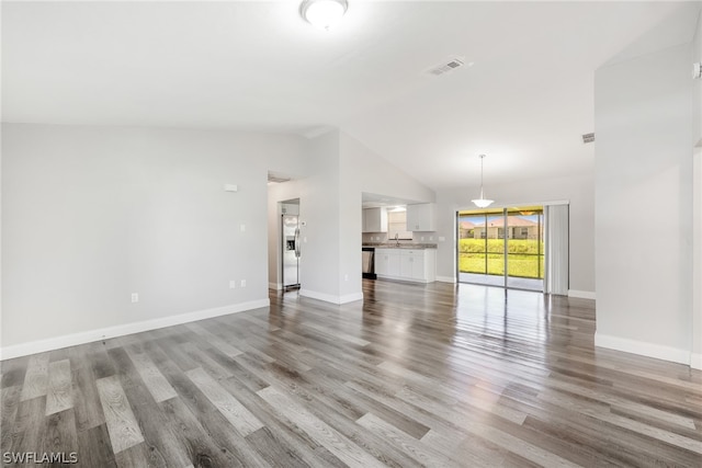 unfurnished living room featuring sink, wood-type flooring, and high vaulted ceiling