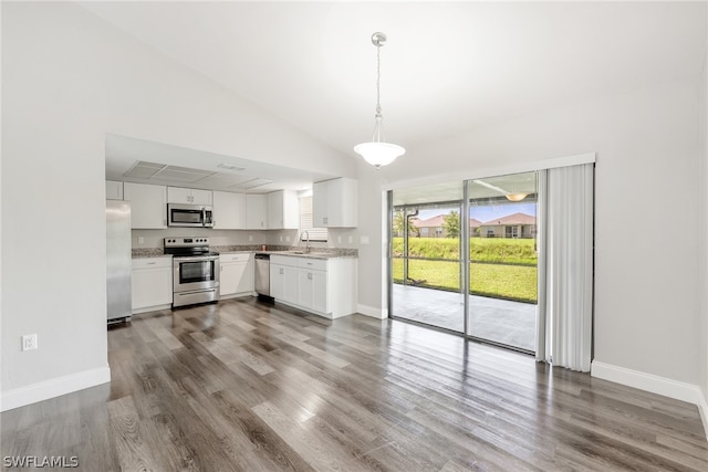 kitchen featuring appliances with stainless steel finishes, sink, decorative light fixtures, white cabinetry, and hardwood / wood-style flooring