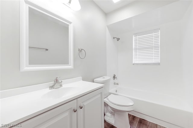 full bathroom with vanity, hardwood / wood-style flooring,  shower combination, and toilet