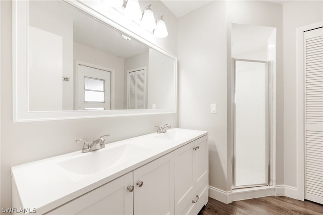 bathroom featuring walk in shower, double sink vanity, and hardwood / wood-style floors