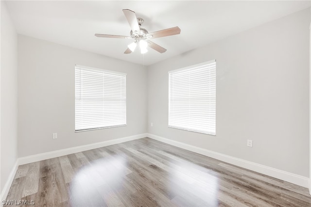 spare room featuring a wealth of natural light, ceiling fan, and light hardwood / wood-style floors