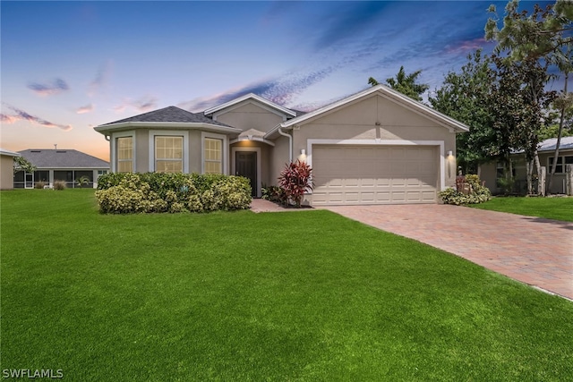 view of front of house with a garage and a yard