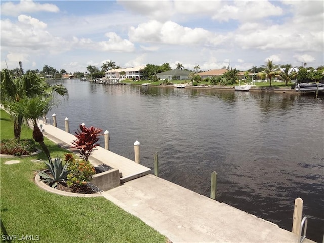 view of dock featuring a lawn and a water view