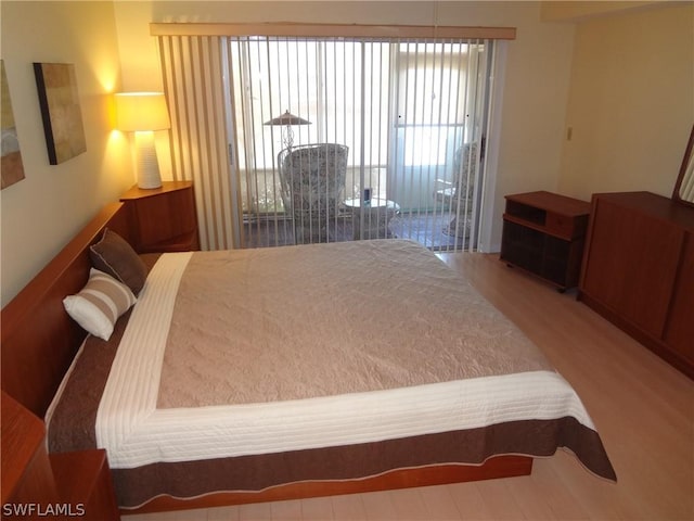 bedroom featuring access to exterior and hardwood / wood-style floors