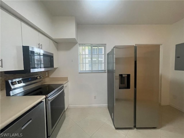 kitchen with electric panel, white cabinetry, light tile patterned flooring, and appliances with stainless steel finishes