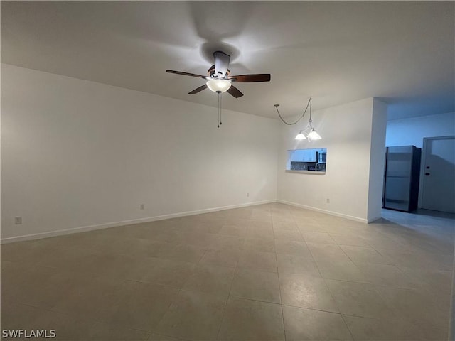 empty room featuring ceiling fan with notable chandelier