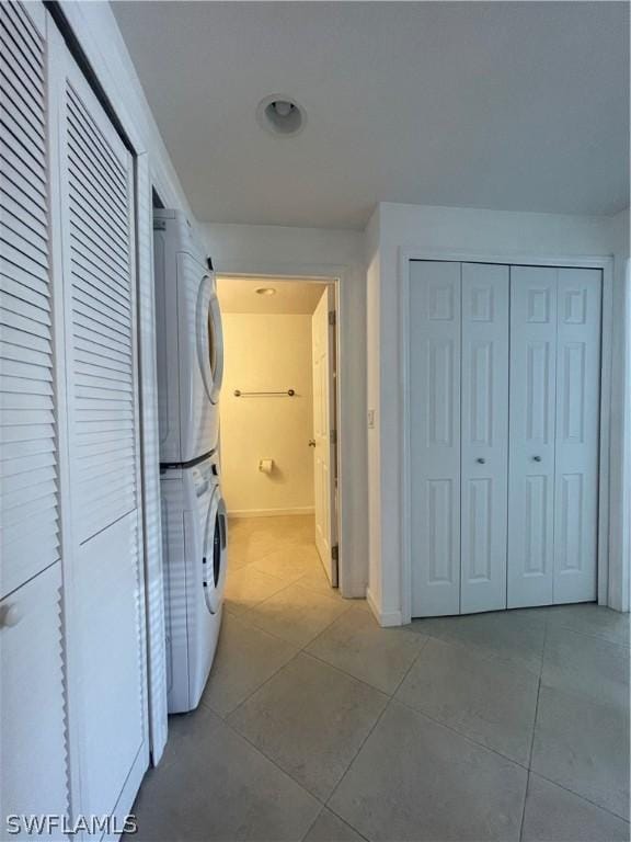 washroom featuring light tile patterned floors and stacked washer and clothes dryer