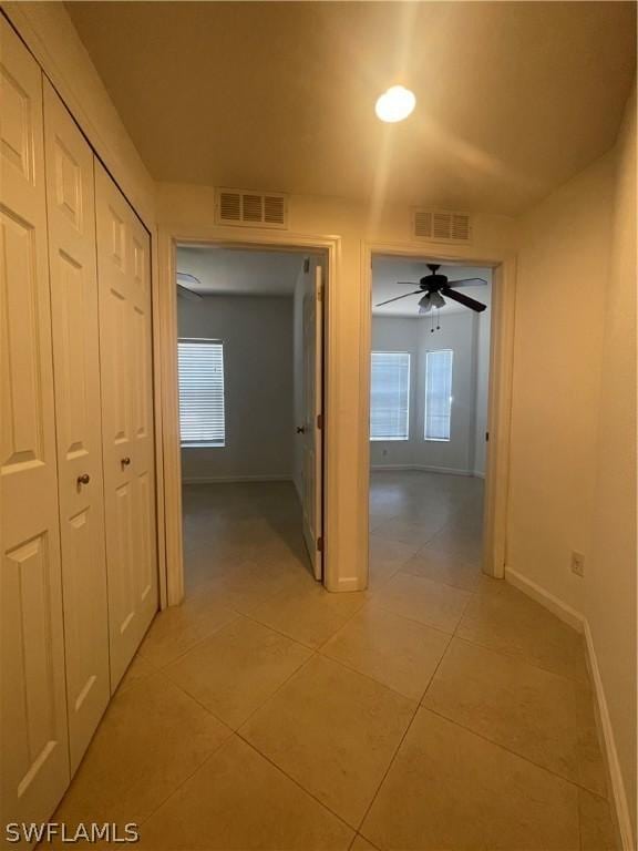 hall featuring light tile patterned flooring and a healthy amount of sunlight