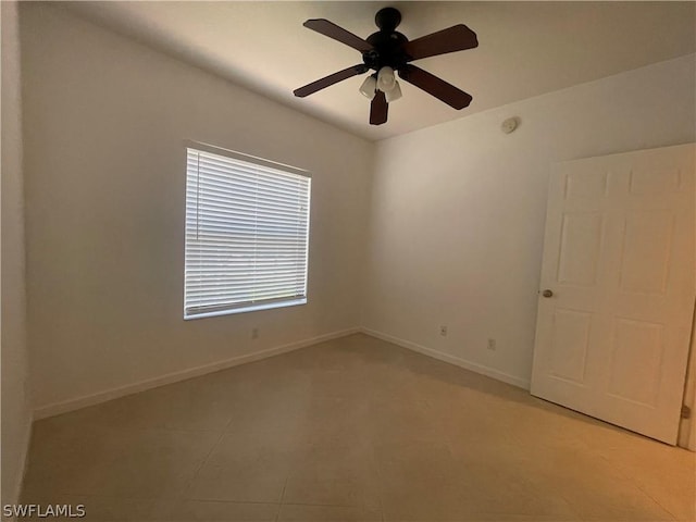 tiled spare room with ceiling fan