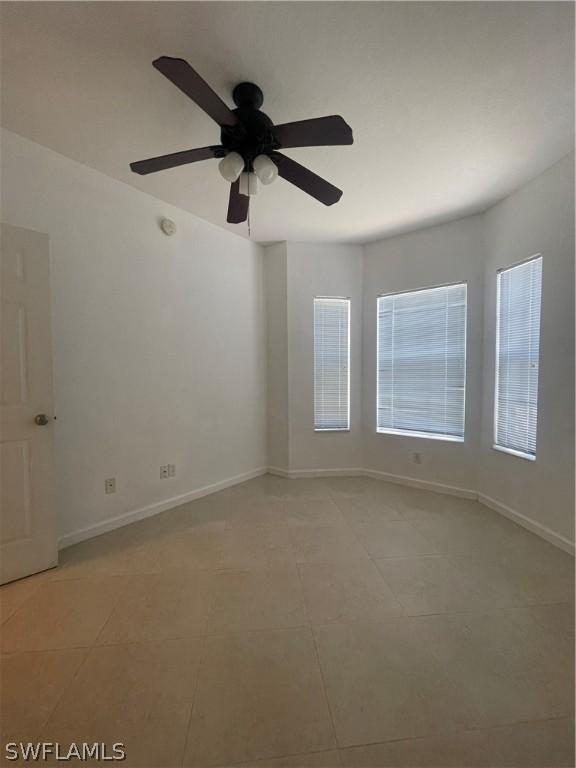 empty room featuring ceiling fan and light tile patterned floors