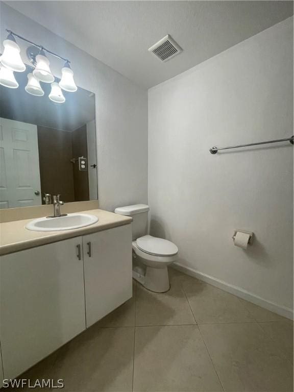 bathroom with tile patterned flooring, vanity, and toilet