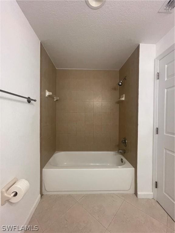 bathroom with tile patterned flooring, a textured ceiling, and tiled shower / bath combo