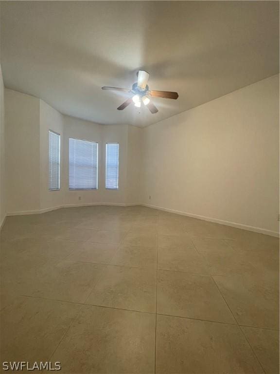 tiled spare room with ceiling fan