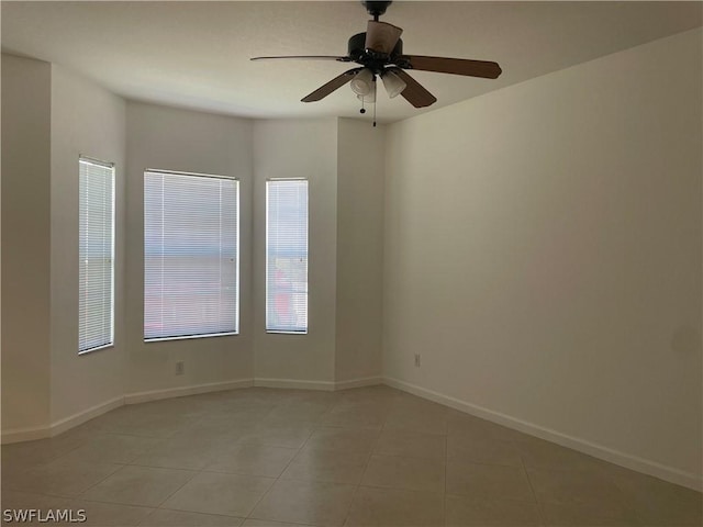 spare room with ceiling fan and light tile patterned floors