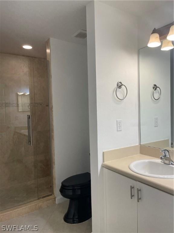 bathroom featuring tile patterned floors, vanity, toilet, and an enclosed shower