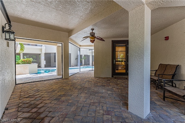 view of patio featuring ceiling fan and a lanai