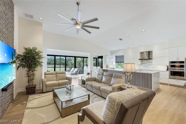 living room featuring lofted ceiling, light hardwood / wood-style floors, ceiling fan, and plenty of natural light