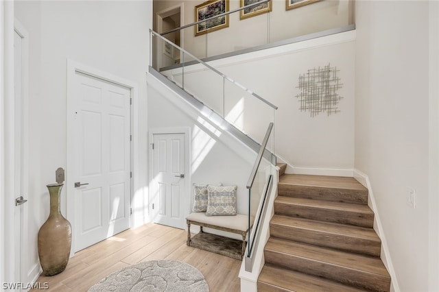 stairway featuring a high ceiling and hardwood / wood-style flooring