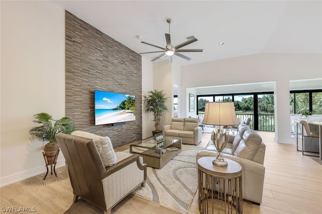 living room with ceiling fan, light hardwood / wood-style flooring, and lofted ceiling