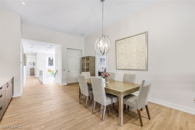 dining area featuring light hardwood / wood-style floors and a notable chandelier