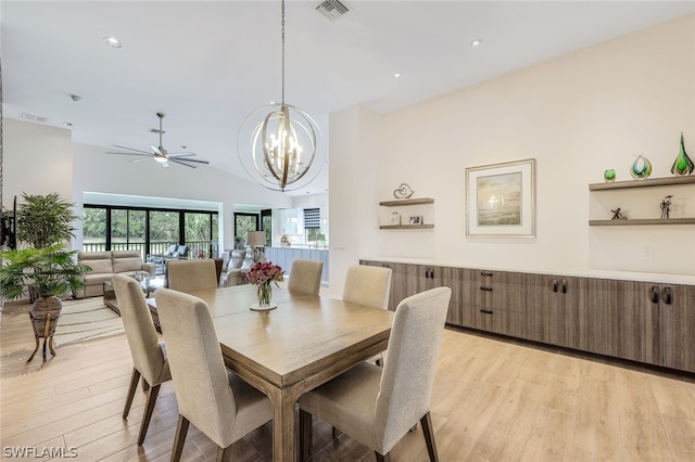 dining room featuring ceiling fan with notable chandelier, lofted ceiling, and light wood-type flooring