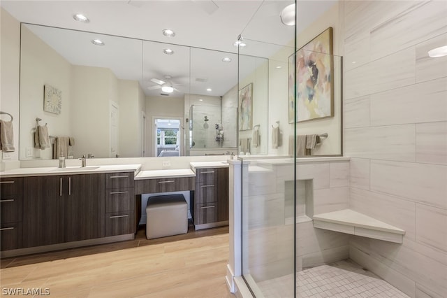 bathroom featuring ceiling fan, a shower with shower door, vanity, and hardwood / wood-style flooring