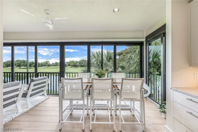 sunroom / solarium featuring a water view