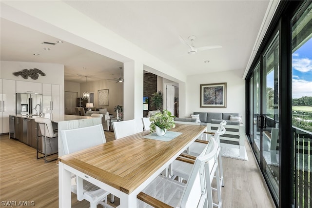 dining area with sink, ceiling fan, and light hardwood / wood-style floors