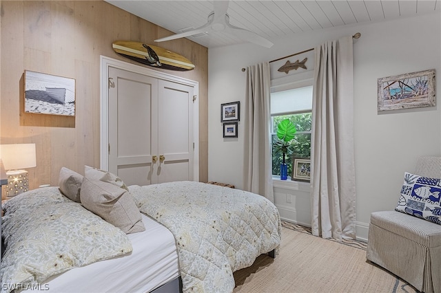 bedroom featuring ceiling fan and wood walls