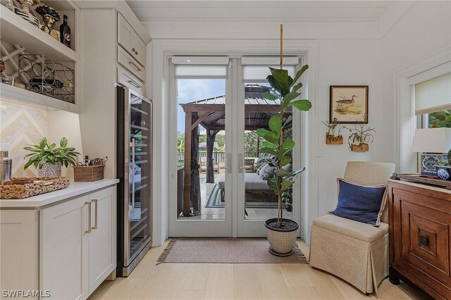 doorway to outside with light hardwood / wood-style flooring and wine cooler