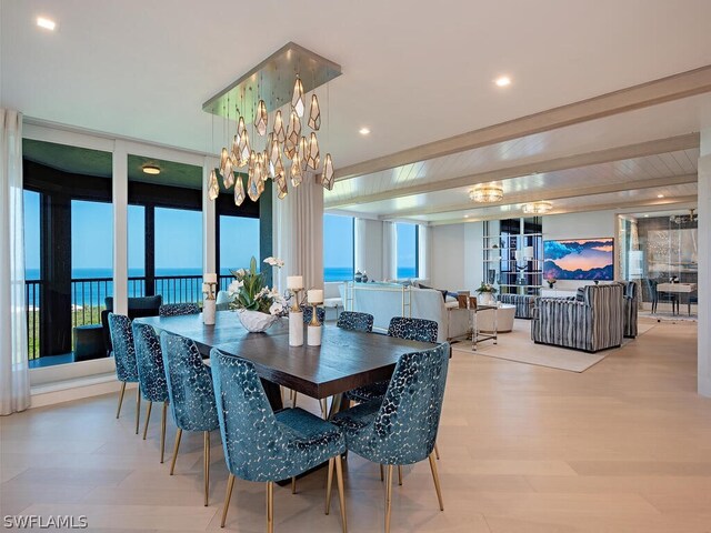 dining space featuring a wall of windows, a water view, hardwood / wood-style floors, and a chandelier