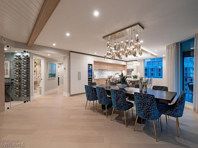 dining space with beamed ceiling and light hardwood / wood-style flooring