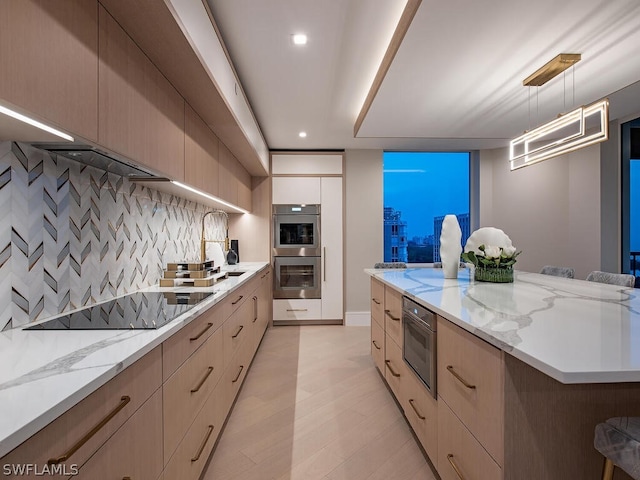 kitchen with tasteful backsplash, black electric stovetop, hanging light fixtures, stainless steel double oven, and a kitchen bar