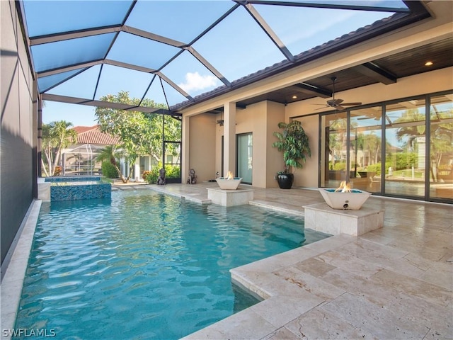 view of pool featuring glass enclosure, a patio area, an in ground hot tub, and ceiling fan