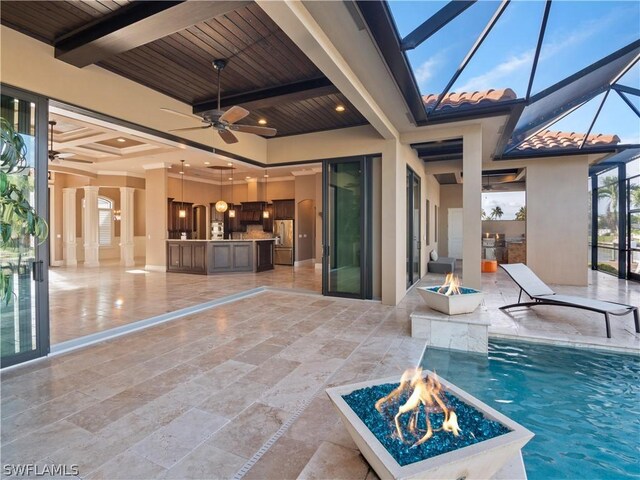 outdoor pool featuring a lanai, a patio area, ceiling fan, and a fire pit