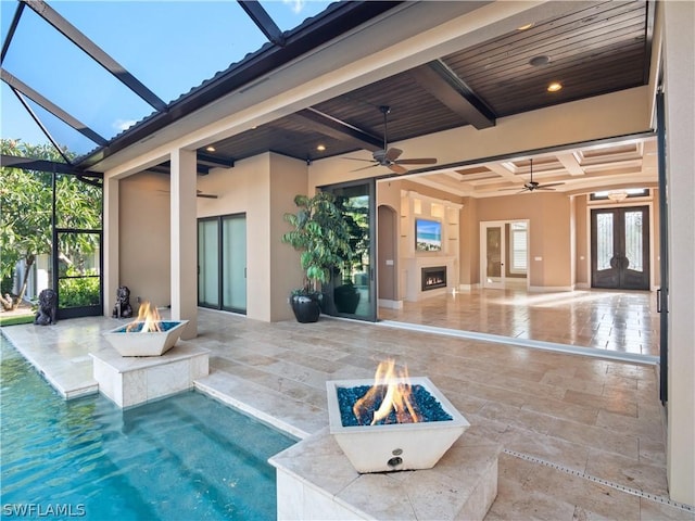 exterior space featuring french doors, a patio, a ceiling fan, an outdoor fire pit, and a lanai