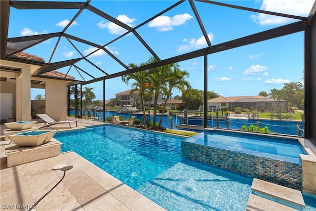 view of pool with a patio, glass enclosure, a water view, and a pool with connected hot tub