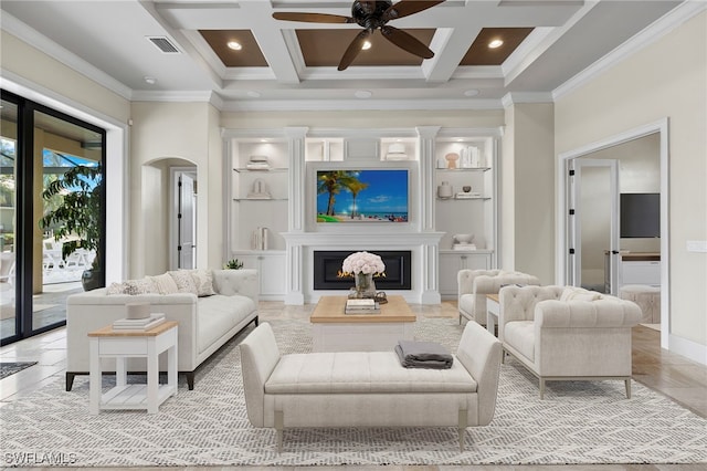 living room with coffered ceiling, arched walkways, visible vents, and a glass covered fireplace