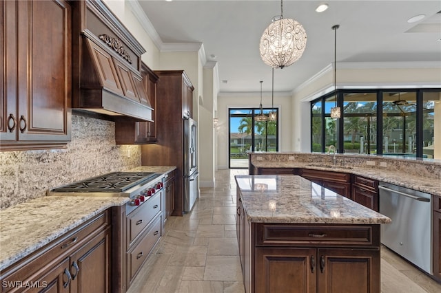 kitchen with tasteful backsplash, stone tile floors, appliances with stainless steel finishes, custom exhaust hood, and a sink