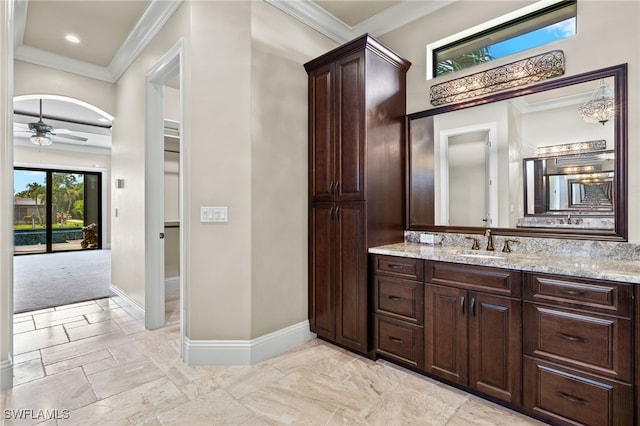 bathroom with a ceiling fan, crown molding, vanity, and baseboards