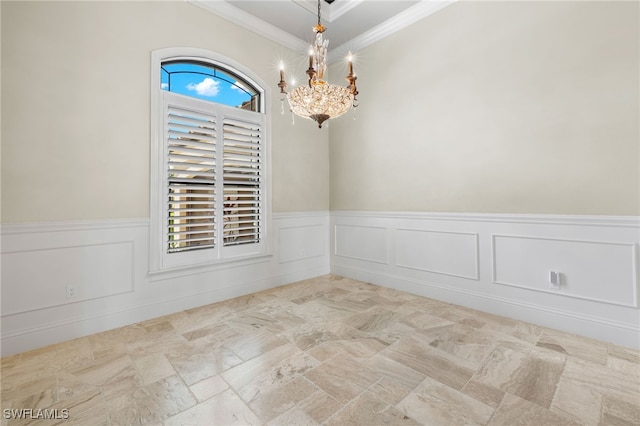 spare room featuring a wainscoted wall, ornamental molding, and a notable chandelier