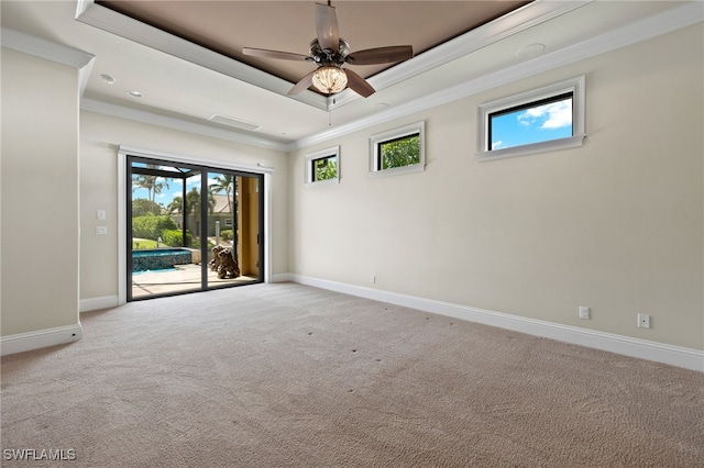 spare room with light carpet, baseboards, a raised ceiling, a ceiling fan, and ornamental molding